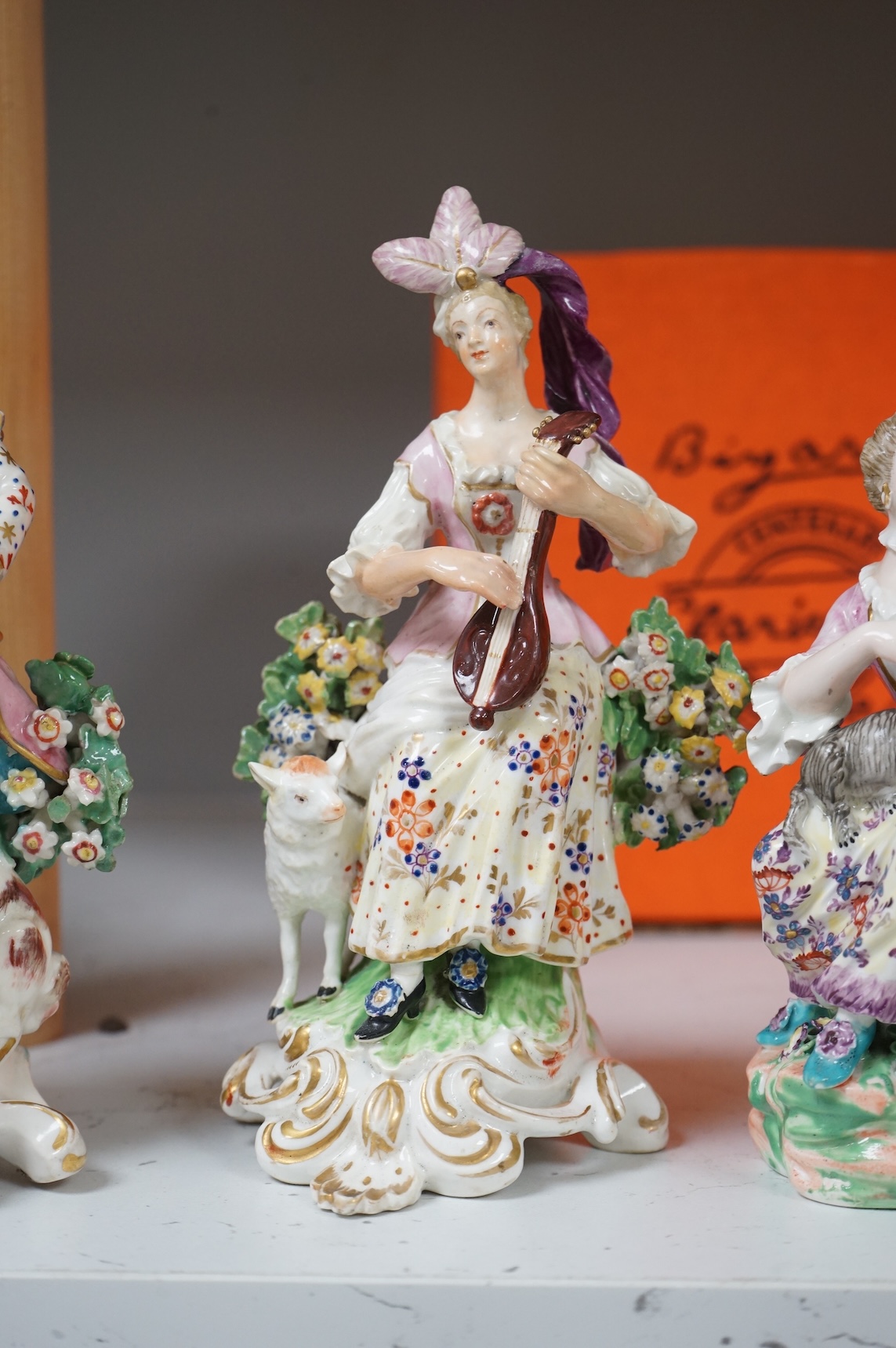A pair of Derby porcelain figures of musicians, and another of a lady and cat, late 18th century, largest 18cm high